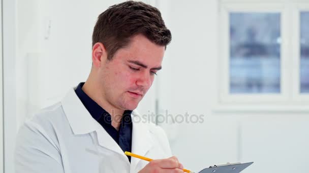 男性医師がクリップボードに何かをノートします。 - 映像、動画