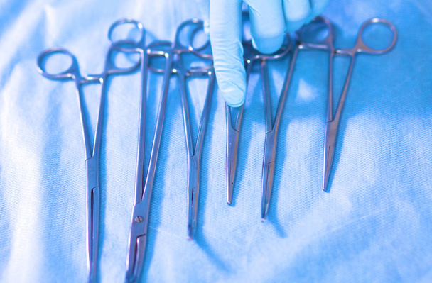 Detail shot of steralized surgery instruments with a hand grabbing  tool - Photo, Image