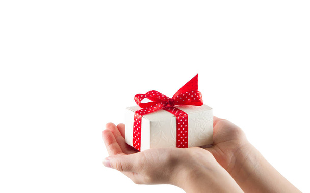 White gift box with red ribbon in hands isolated on white background - Photo, image