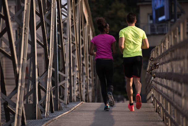 multiethnic couple jogging in the city - Fotó, kép