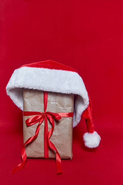 Box gift with Santa Claus hut on red background - Valokuva, kuva