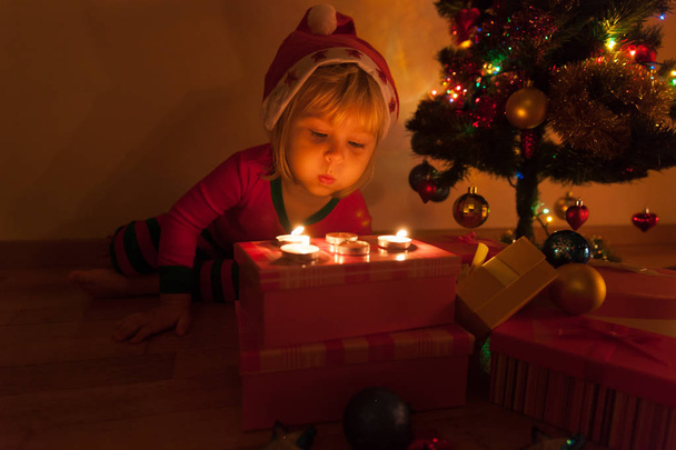 Mumlar Noel'de üfleme neşeli küçük kız - Fotoğraf, Görsel