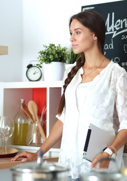 Young woman standing near desk in the kitchen - Foto, Bild