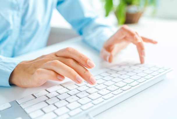 Woman office worker typing on the keyboard - Foto, afbeelding