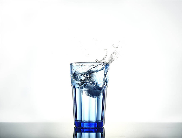 Splash de água com gelo em um copo
 - Foto, Imagem