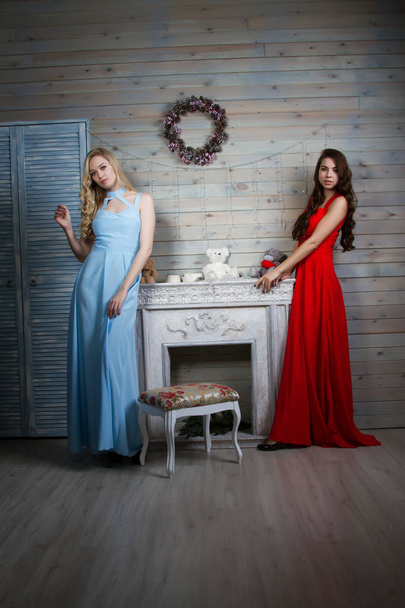 Two young young girls in long gowns in a room with a fireplace - Foto, Bild