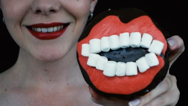 Nahaufnahme weibliche rote Lippen essen Donut und lächeln - Filmmaterial, Video
