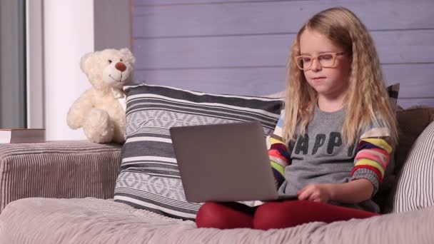 Smiling little girl with laptop computer at home - Footage, Video