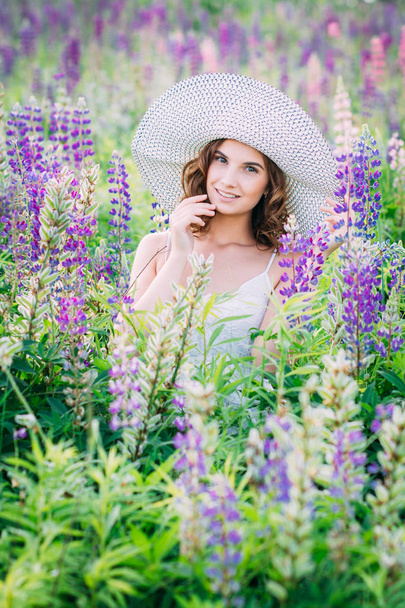 Girl with a bouquet of lupine on the field - Фото, зображення