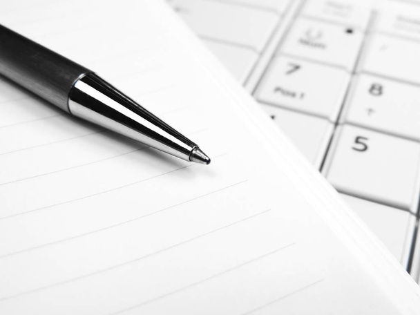 ペンと紙の白のノート パソコンのキーボード上 - 写真・画像