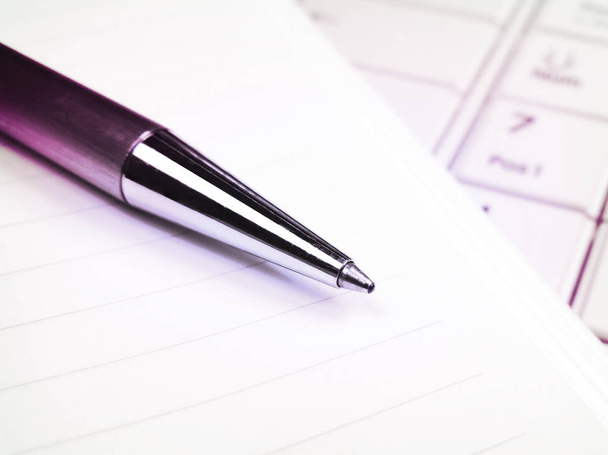 Πένα και το χαρτί σε ένα λευκό φορητό πληκτρολόγιο - Φωτογραφία, εικόνα