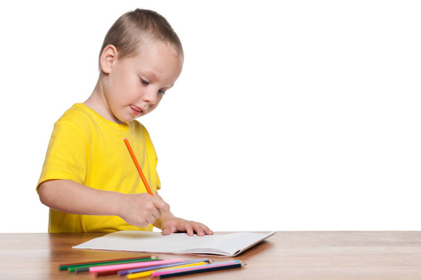 Little boy sits at the desk and write - Foto, imagen