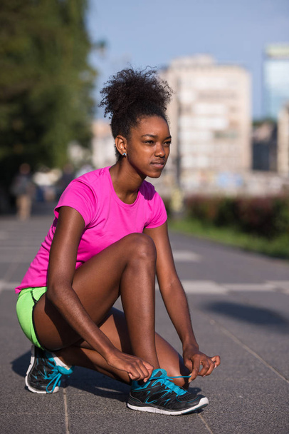 African american woman runner tightening shoe lace - Fotoğraf, Görsel