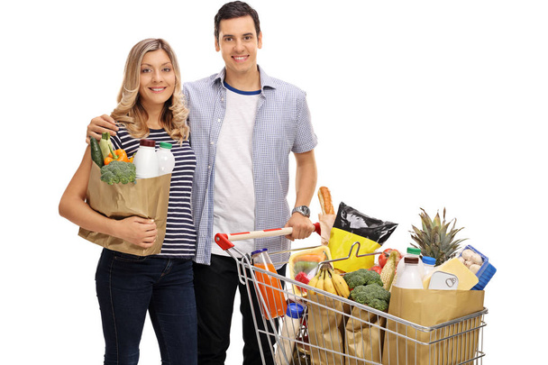 couple with a shopping bag and a cart filled with groceries - Foto, immagini