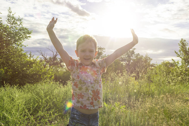 Enfant actif passant du bon temps sur la prairie d'été au coucher du soleil
 - Photo, image