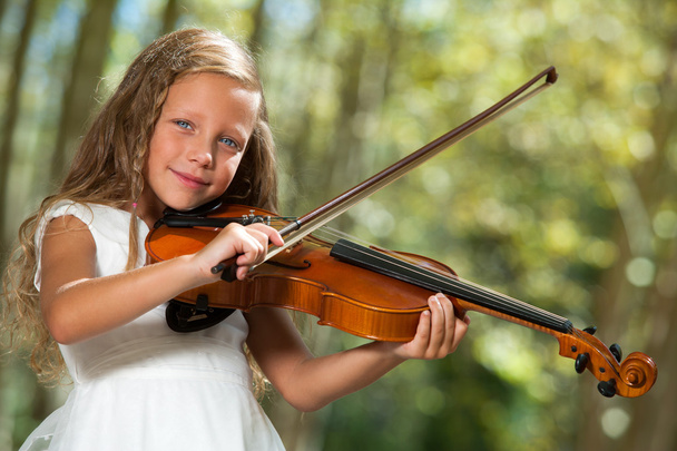 Jolie fille en blanc jouer du violon en plein air
. - Photo, image