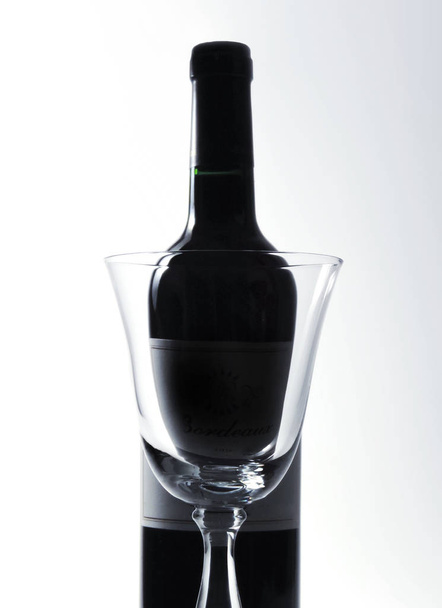 Red wine bottle and elegant wineglas - 写真・画像