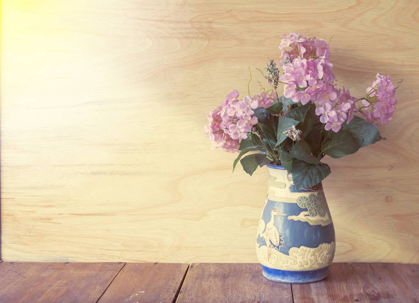 Růžový květ ve váze s dřevěnou pozadí - Fotografie, Obrázek