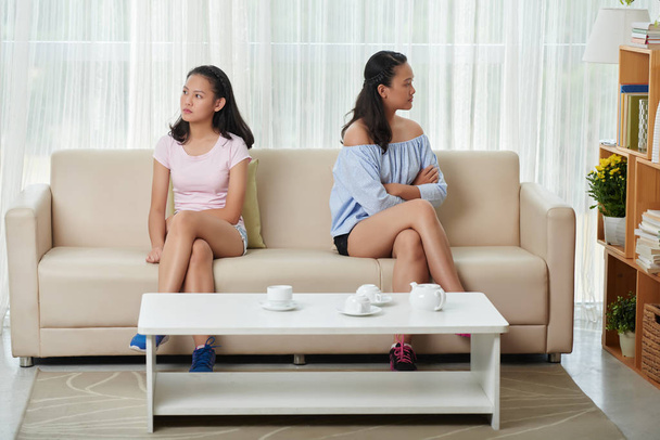  siskot istuvat sohvalla riidan jälkeen
 - Valokuva, kuva