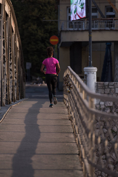 african american woman running across the bridge - Photo, Image