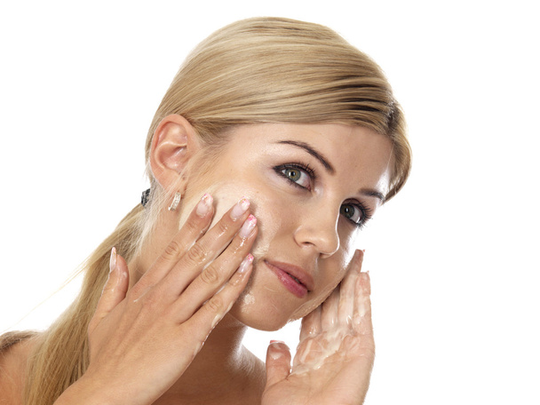 Mujer joven aplicando crema facial hidratante
 - Foto, imagen