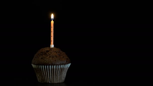 Záběry muffin s svíčku zblízka na černém pozadí. 4k video - Záběry, video
