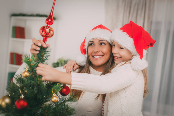 Madre y Dughter decorando el árbol de Navidad
 - Foto, Imagen