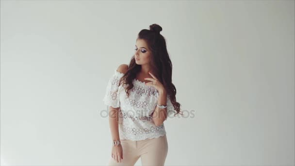 junge hübsche Frau brünett posiert im Studio auf weißem Hintergrund - Filmmaterial, Video