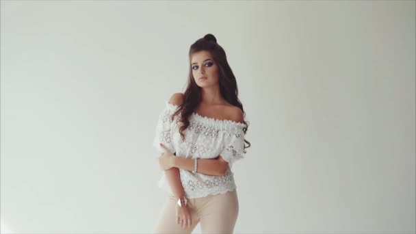 Fiatal gyönyörű nő barna pózol stúdió fehér háttér - Felvétel, videó