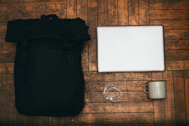 Tasche, Tasse, Kopfhörer und Laptop auf Holzuntergrund aus Brettern - Foto, Bild