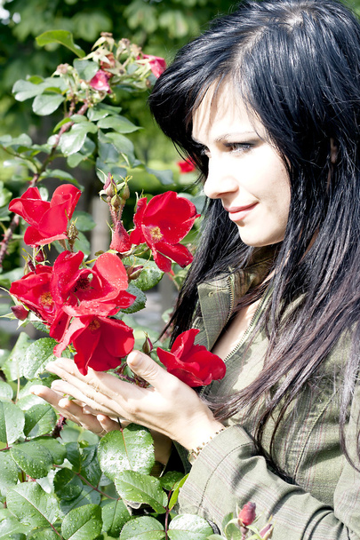 krásná brunetka v blízkosti červené růže - Fotografie, Obrázek