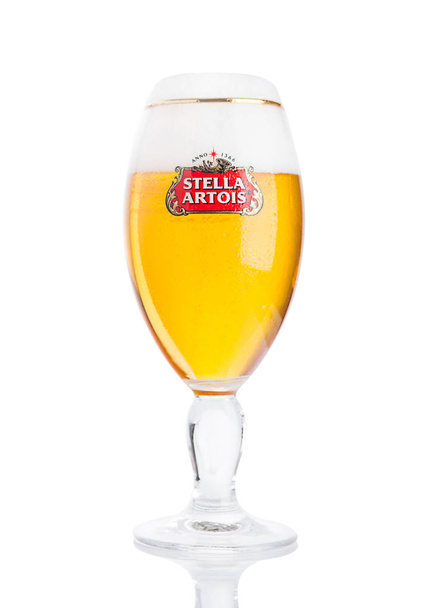 LONDON, UK -NOVEMBER 29. 2016  Cold glass of Stella Artois beer on white background, prominent brand of Anheuser-Busch InBev, is a pilsner brewed in Leuven, Belgium, since 1926 - Foto, Bild