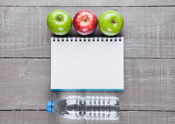 ΣΗΜΕΙΩΜΑΤΑΡΙΟ με μήλα και νερό ως δίαιτα ιδέα - Φωτογραφία, εικόνα