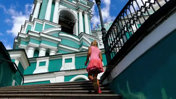 Szép kislány sétál templom Mária Mennybevitele-székesegyházra, dominál a város Szmolenszk, Orosz Föderáció, a magasztos katedrális Hill közelében. - Felvétel, videó