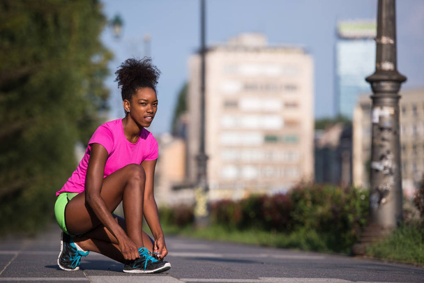 African american woman runner tightening shoe lace - Valokuva, kuva