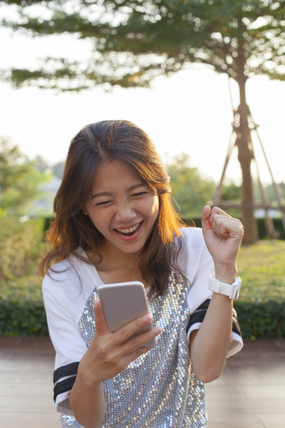 junge asiatische Frau schaut auf Handy-Bildschirm mit Überraschung - Foto, Bild