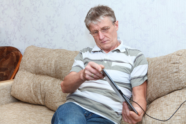 Anciano conectado en internet con pestaña electrónica
 - Foto, imagen