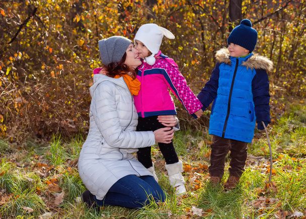 Mutter mit Kindern spaziert im Herbstpark - Foto, Bild