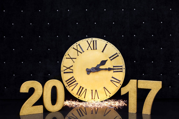 Noël grande montre en or avec chiffres latins sur un fond de luxe noir. avec espace de copie. Nombres de nouvelle année 2017 couleur or sur sol sombre brillant
. - Photo, image
