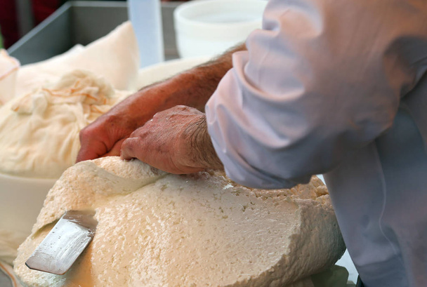 homme coupe le fromage fraîchement préparé dans la laiterie
 - Photo, image