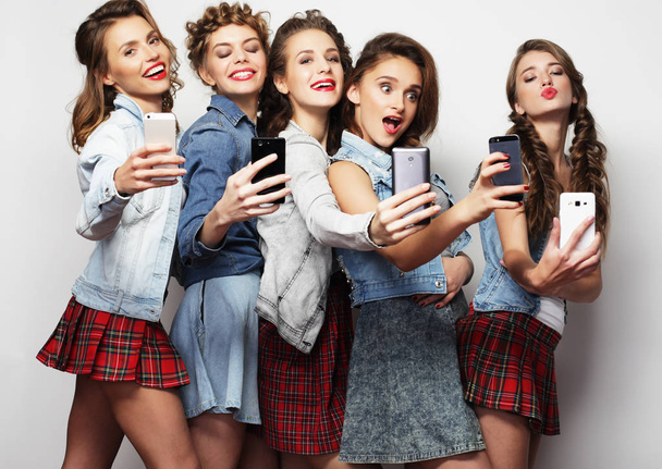 group of young women looking at their smartphones - Foto, Imagem