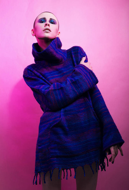 Young fashion model posing over pink background - 写真・画像