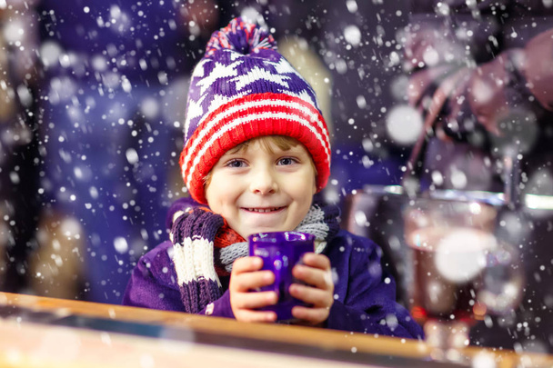 Малыш с горячим шоколадом на рождественской ярмарке
 - Фото, изображение