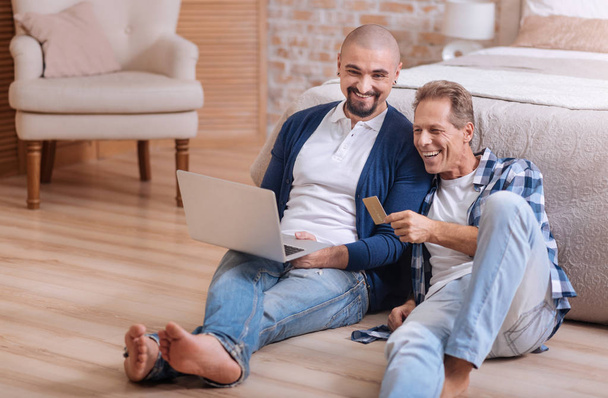 Gay couple looking at the laptop and having fun - Фото, зображення