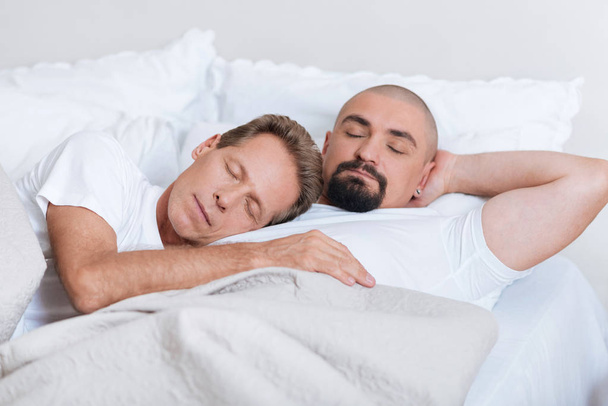 Peaceful non-traditional couple sleeping together - Фото, изображение