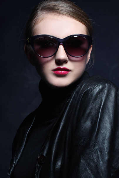 Beautiful and fashion woman in sunglasses, studio shot. Professional makeup and hairstyle - Foto, afbeelding