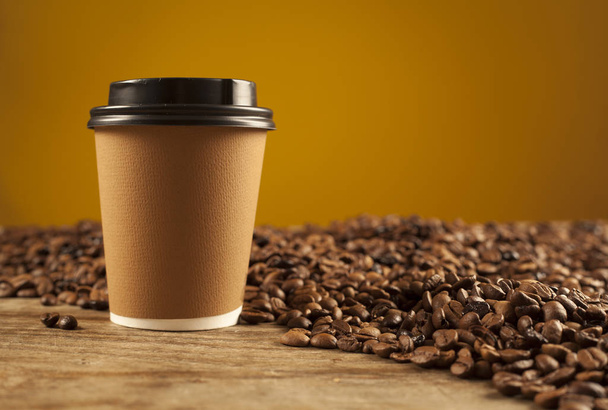 Paper cup of coffee on brown background - Photo, image