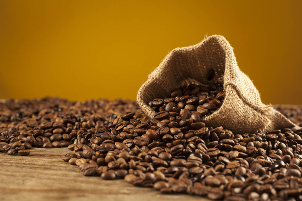 Ziarna kawy w worek na brązowym tle - Zdjęcie, obraz