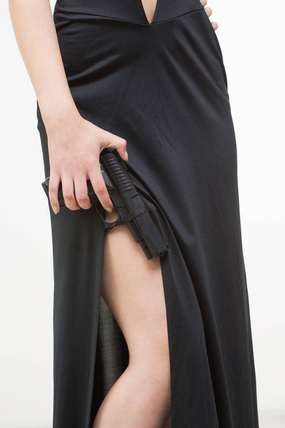 sexy woman in black dress holding gun - Foto, afbeelding