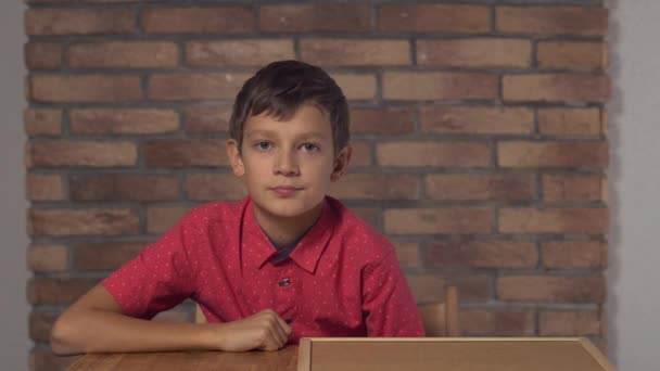 lapsi istuu pöydän ääressä pitäen flipchart kirjoitus trendi taustalla punainen tiili seinään
 - Materiaali, video